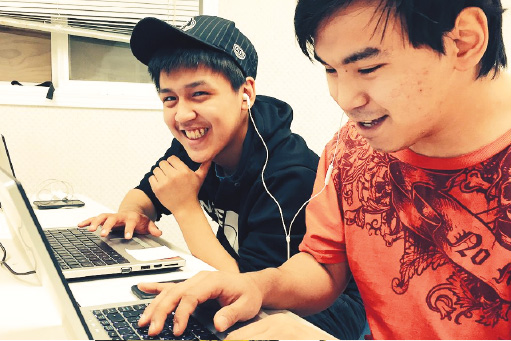 Two kids working on their laptops