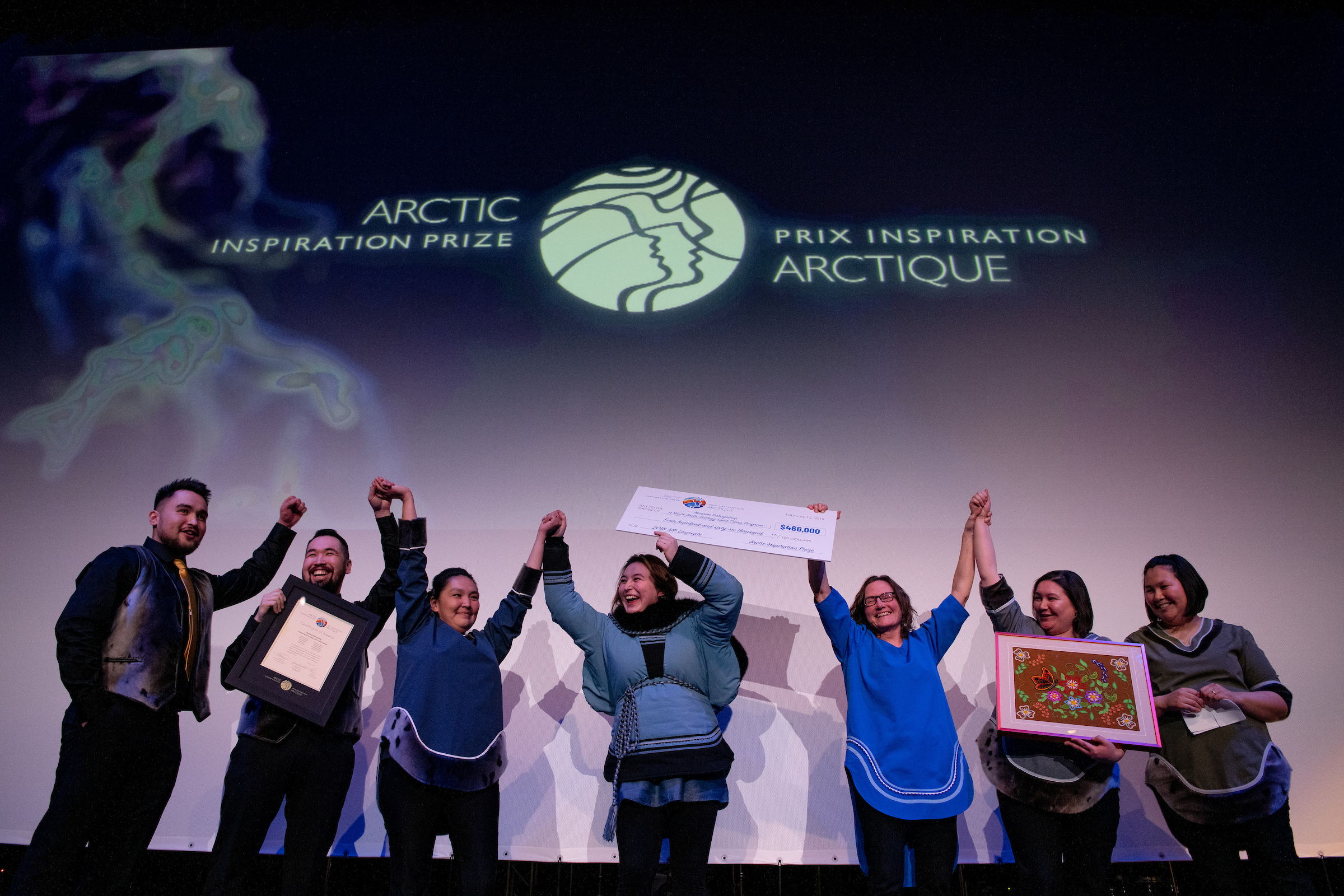 AIP Laureates celebrate their win on stage with a giant cheque.