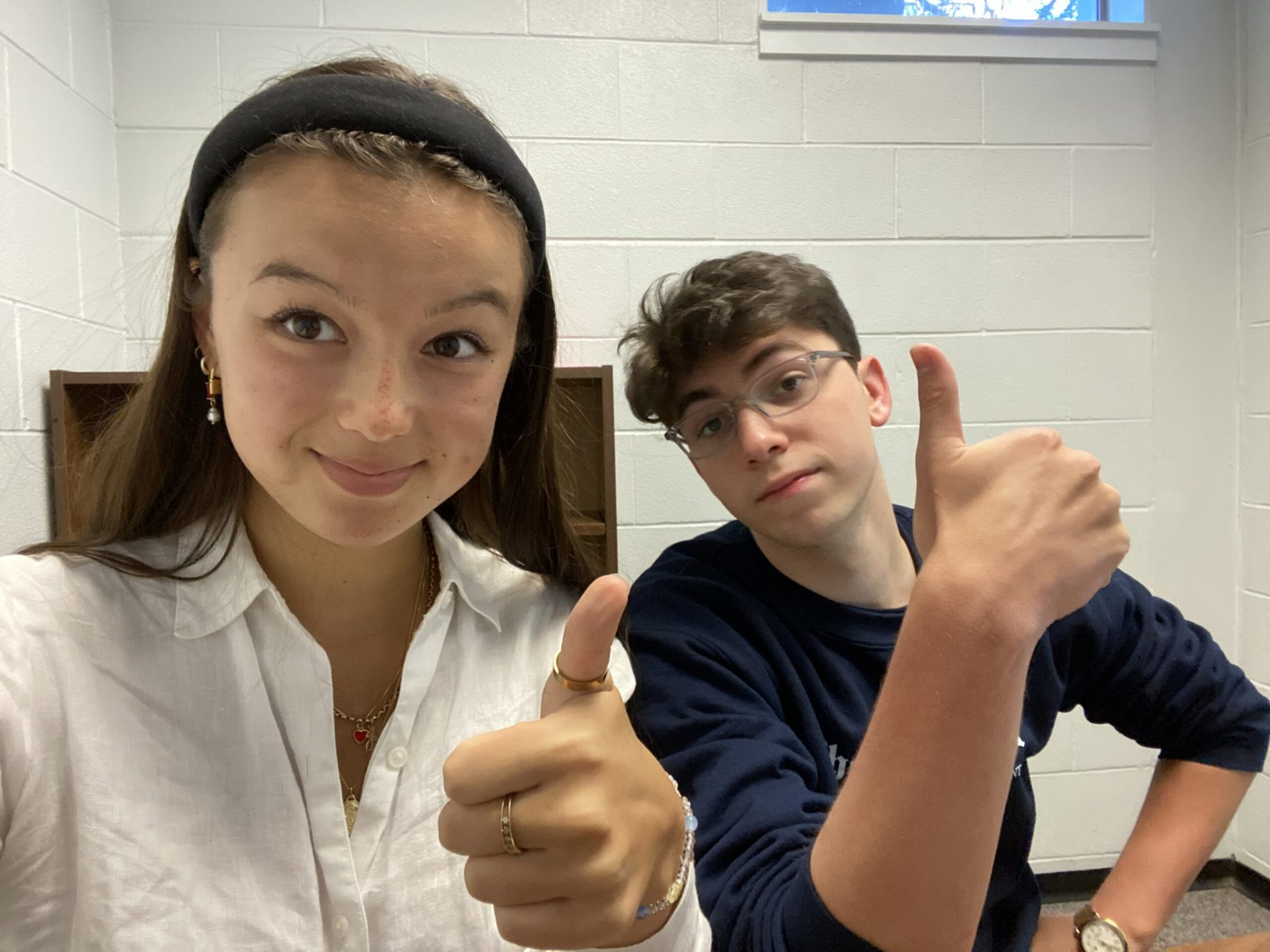 two students giving thumbs up