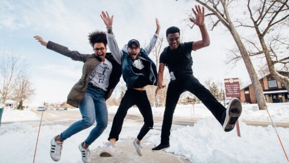 Three youth jumping for joy