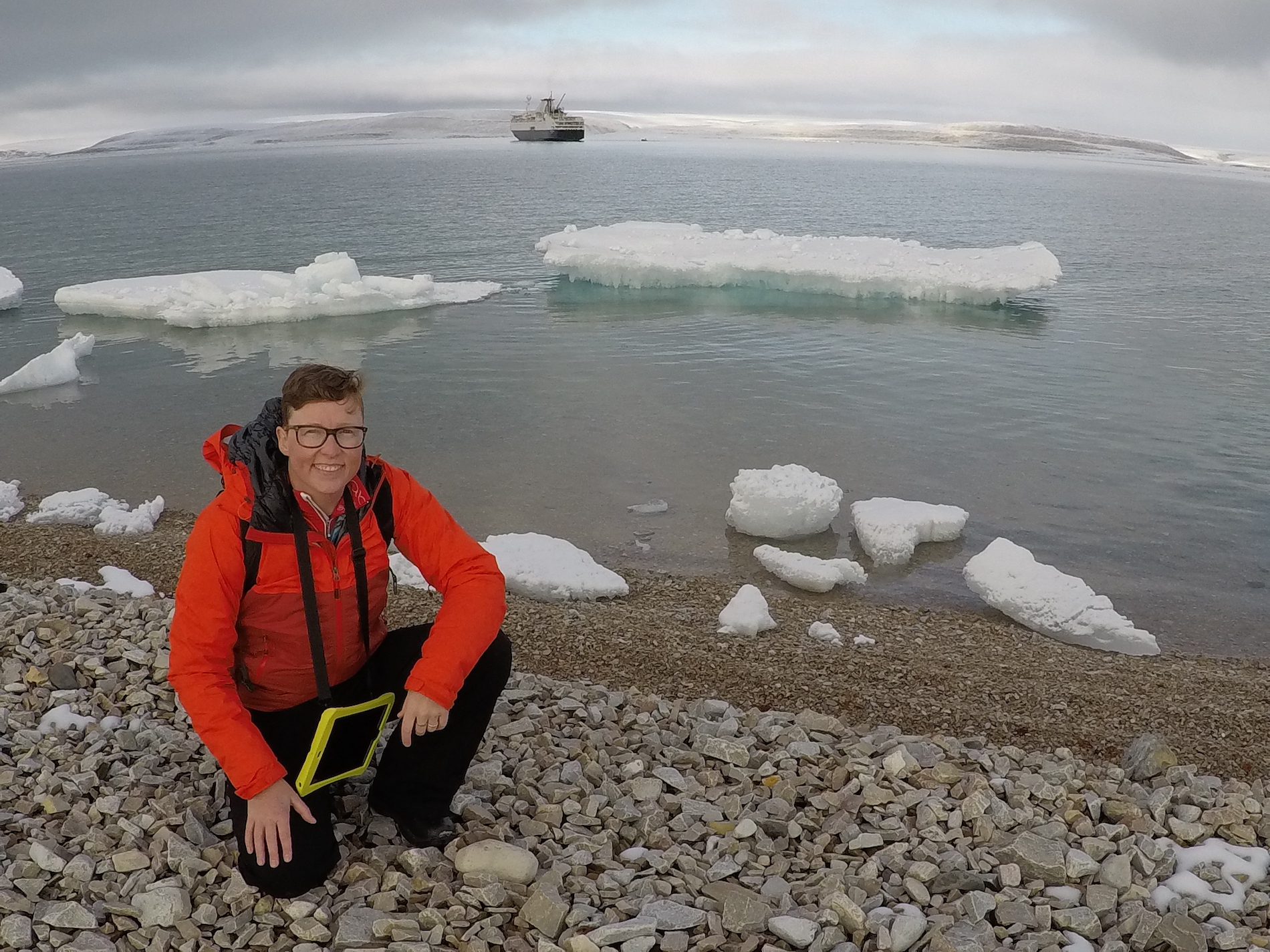 person posing in front of water with icebergs