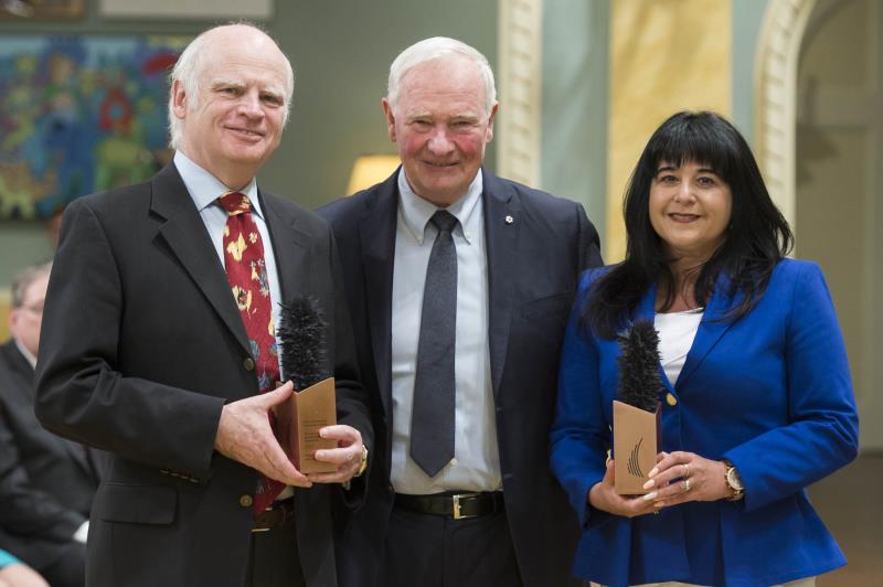 three people posing with award