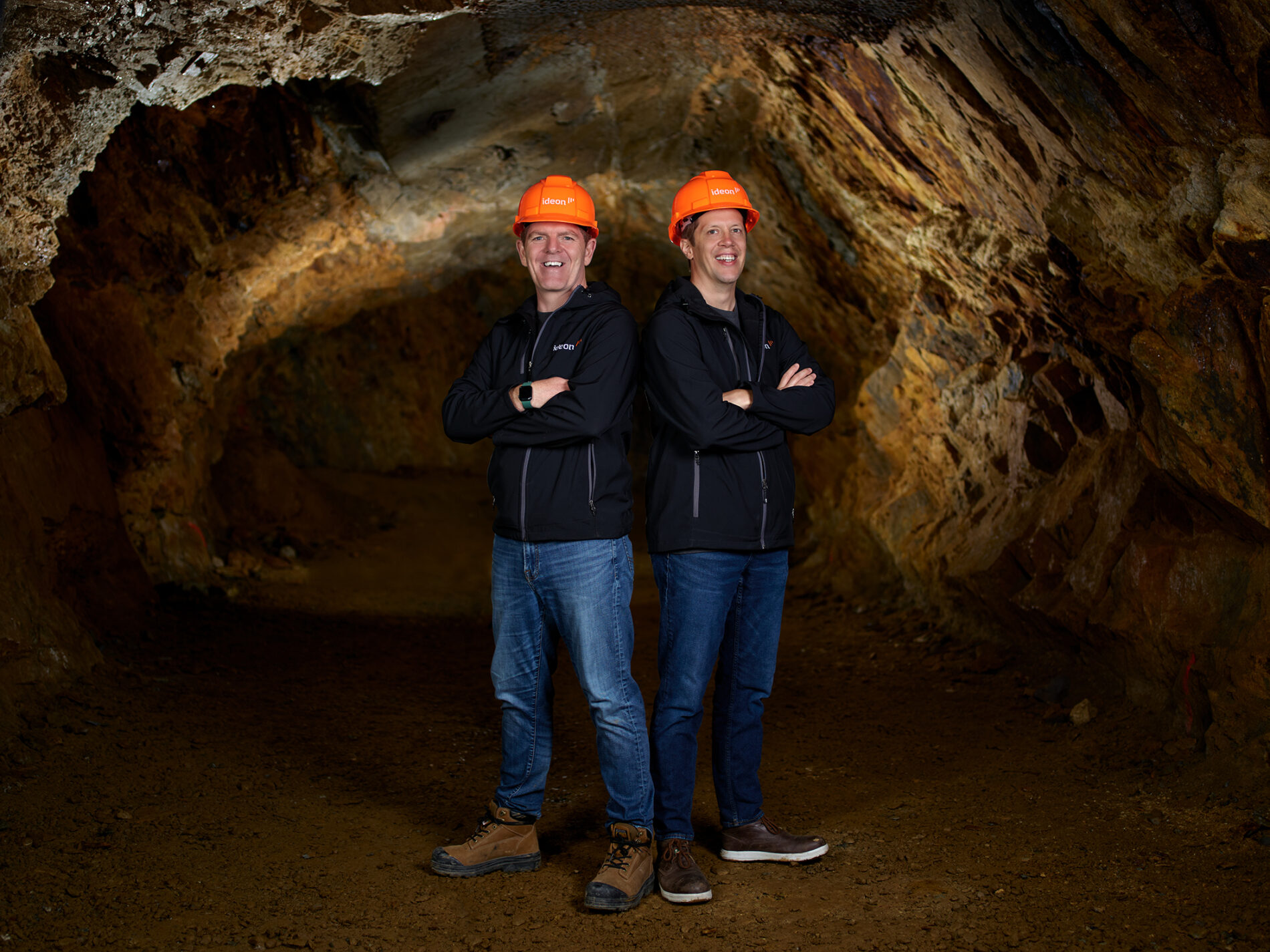 two people posing underground in hard hats