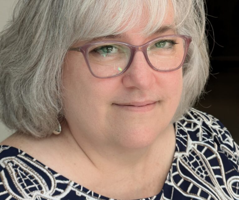 A headshot of a woman wearing glasses.